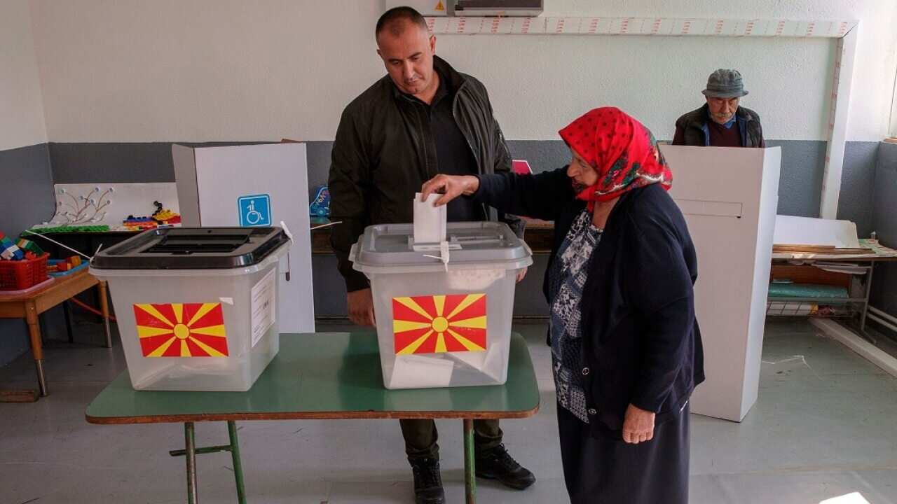 A woman casts her vote in a referendum on the country's name change at a polling station in the village of Zajas.