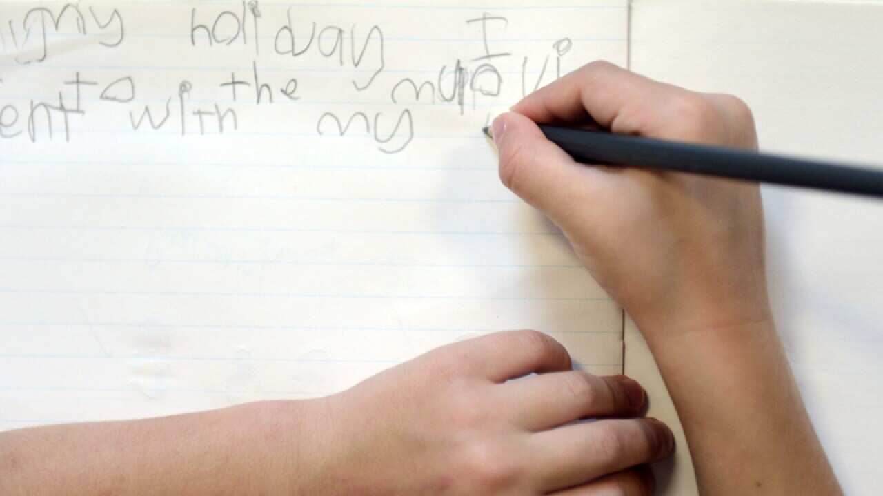 A school students writes in a notebook