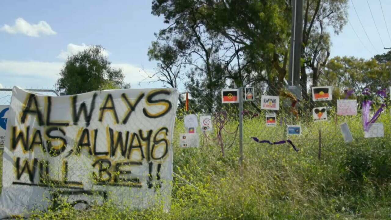 Signs of protest and solidarity on the fence of the proposed go-kart track site.