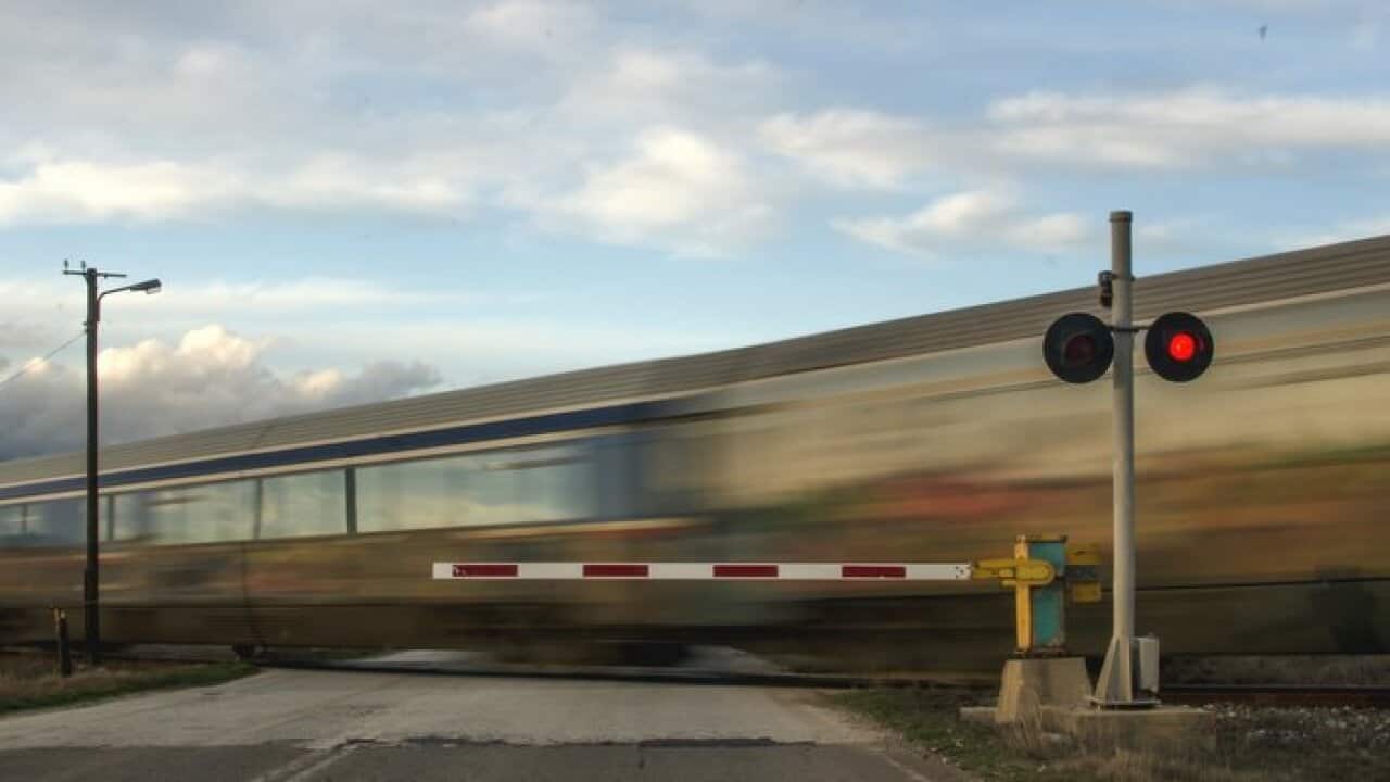 Blurred Motion Of Train By Railroad Crossing Against Sky