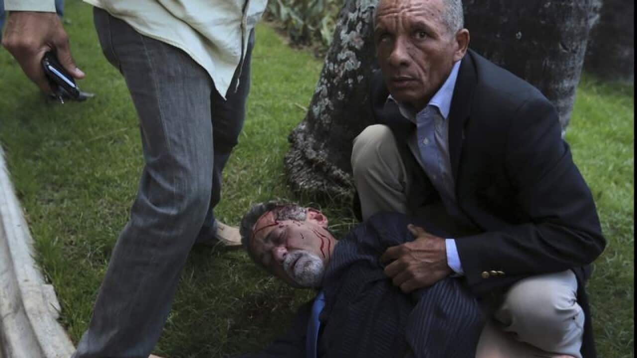 A bodyguard watches over opposition lawmaker Americo De Grazia.