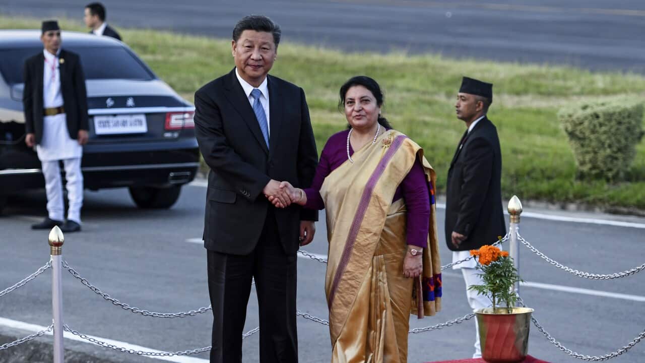 Nepal's President Bidhya Devi Bhandari (R) shakes hands with China's President Xi Jinping (L) at Tribhuvan International Airport in Kathmandu, 12 October 2019.