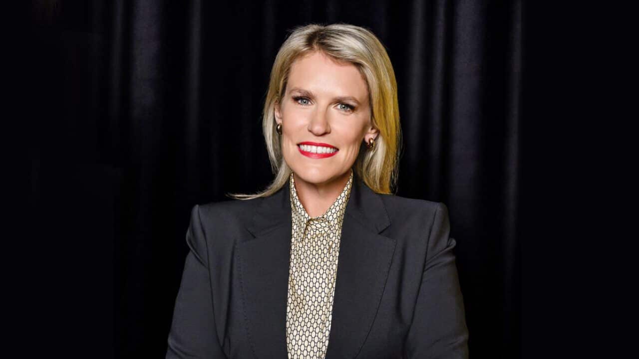 A smiling blonde woman in a blazer.