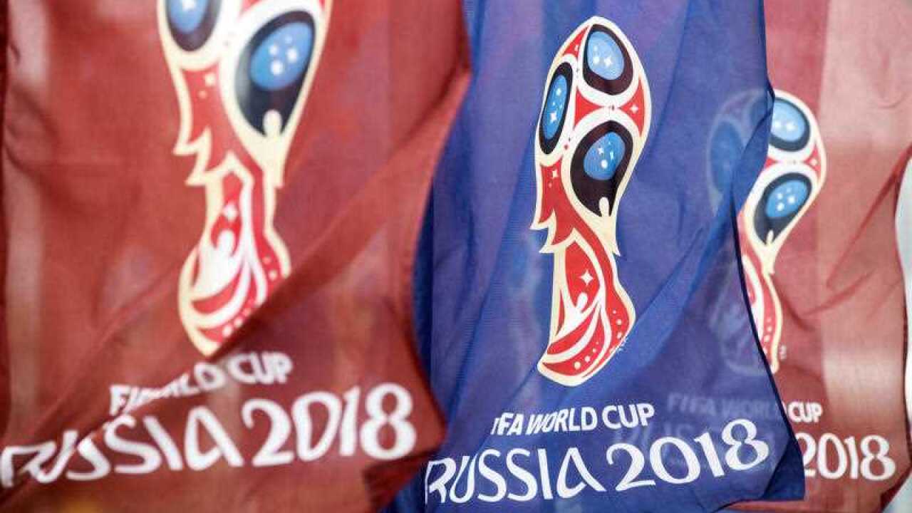Flags with the logo for the 2018 FIFA World Cup flutter in the wind near the World Cup stadium.