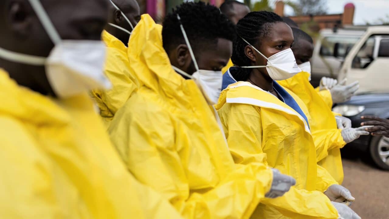 A group of African medics wearing yellow hazard suits and white face masks.