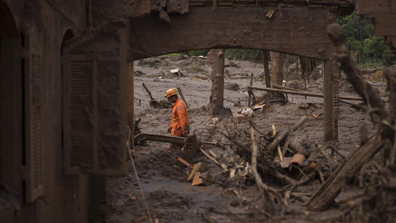 A rescue worker walks between destroyed houses