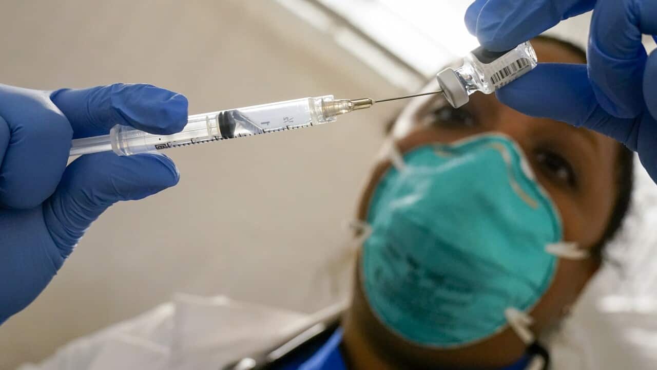 Physician Dr Yomaris Pena extracts the last bit of Pfizer-BioNTech COVID-19 vaccine out of a vial at a vaccination site in East Harlem, New York, on 15 January.