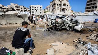 A man sits down staring at rubble.