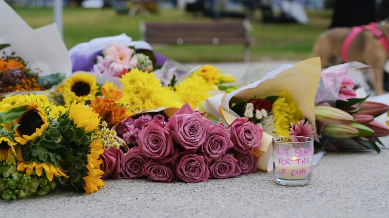 Flowers and candles placed on the ground.