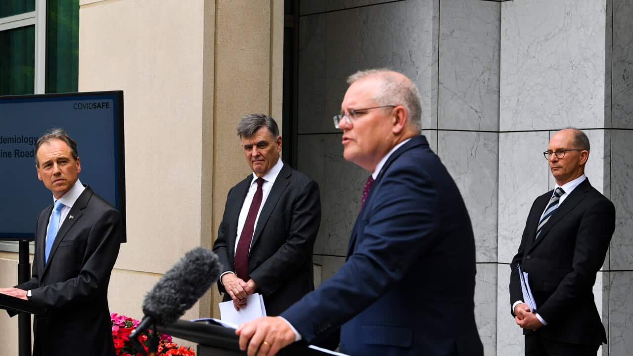 Greg Hunt (left), Brendan Murphy (centre) and Paul Kelly listen to Scott Morrison during a press conference.