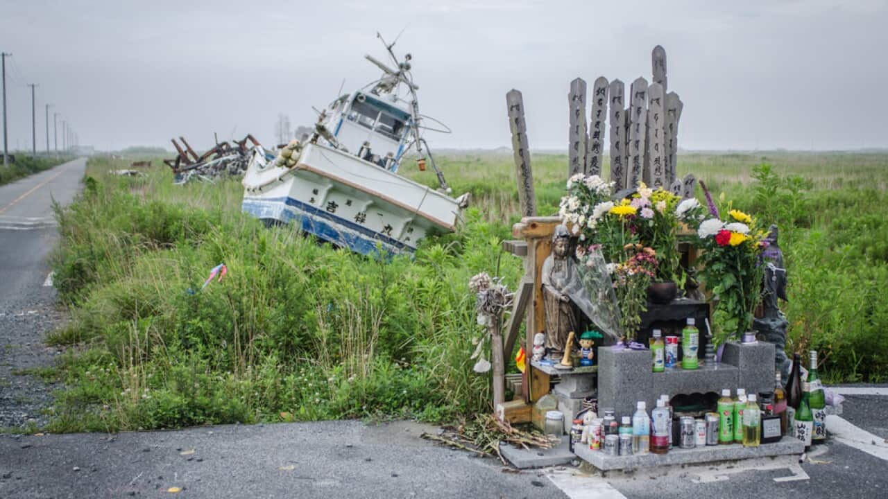 A fishing boat washed inland by the 2011 Tsunami next to a shrine inside the Fukushima nuclear exclusion zone.