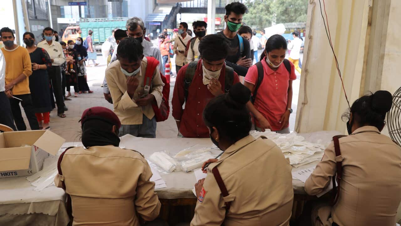Indian commuters queue up COVID-19 tests at an Inter-State Bus Terminal, New Delhi, 24 March 2021.