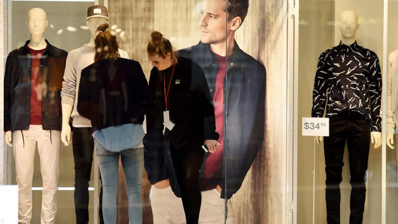 Window dressers adjust mannequins