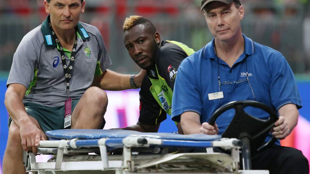 Andre Russell is driven off the pitch after injuring himself
