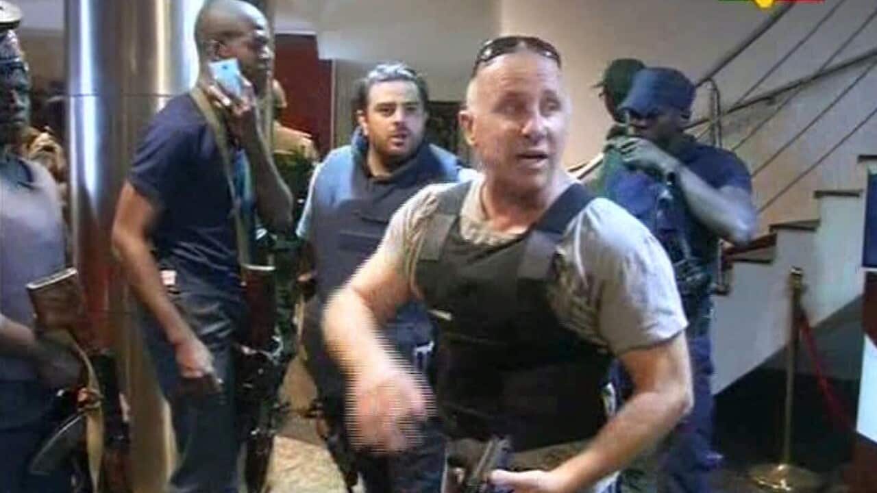 In this TV image taken from Mali TV ORTM, a security officer gives instructions to other security forces inside the Radisson Blu Hotel in Bamako, Mali