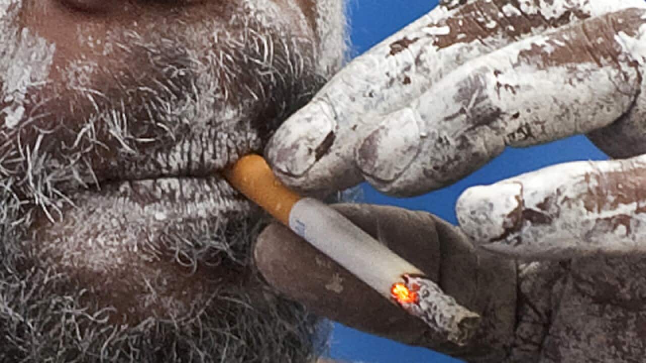 An indigenous person smokes a cigarette
