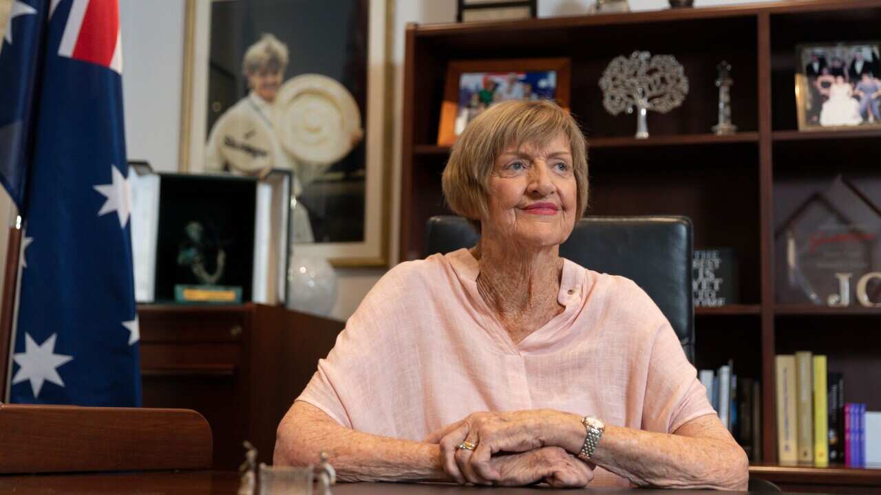 Margaret Court poses for a portrait in her office, 22 January 2021, with a photograph of her she won Wimbledon in 1965.