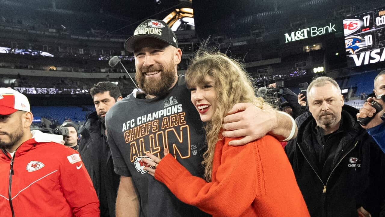 A man with his arm wrapped around a woman, both smiling.