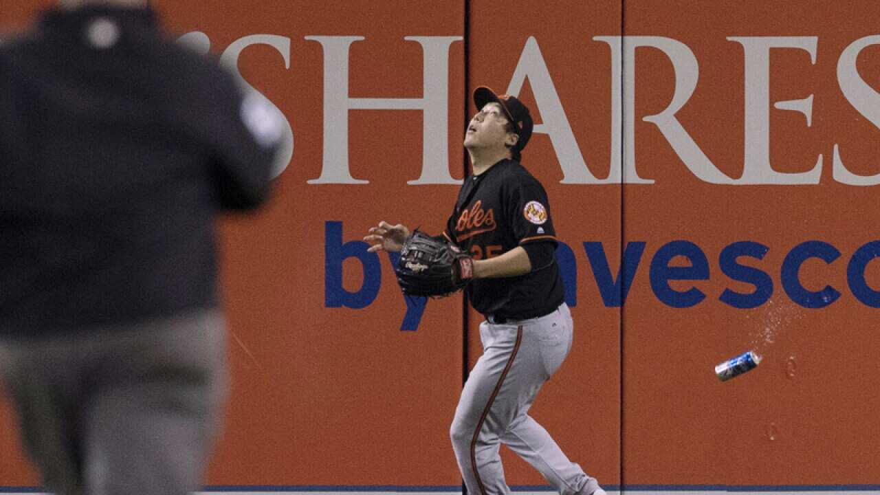 A beer can is thrown near Baltimore Orioles outfielder Kim Hyun-soo