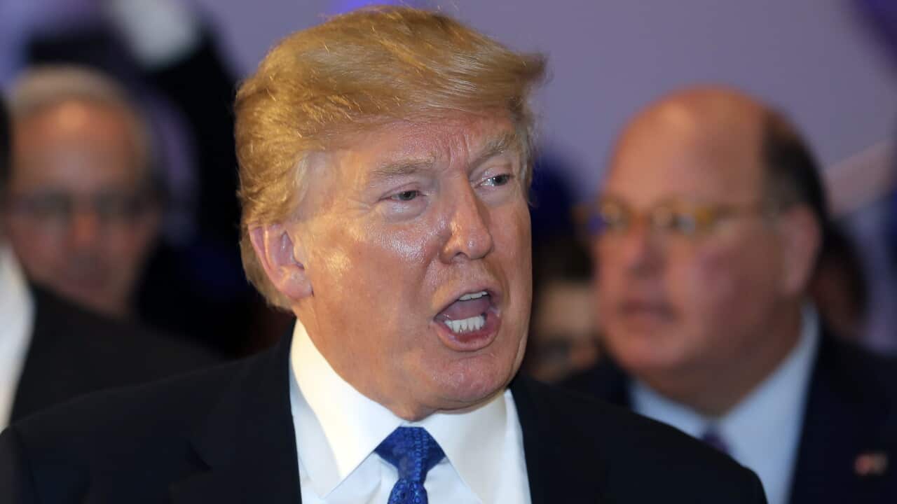 U.S. President Donald Trump speaks as he walks during the annual meeting of the World Economic Forum. (AAP)