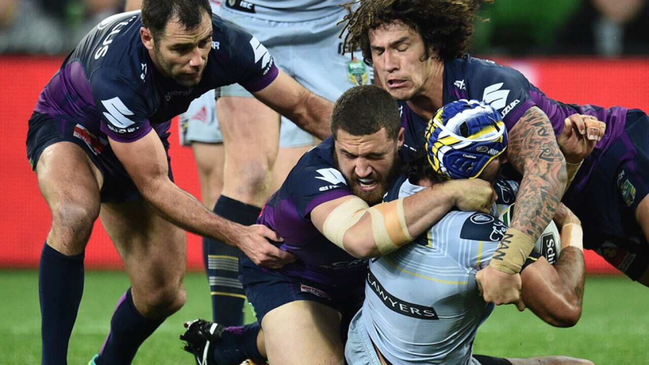 Storm players tackle Johnathan Thurston of the Cowboys