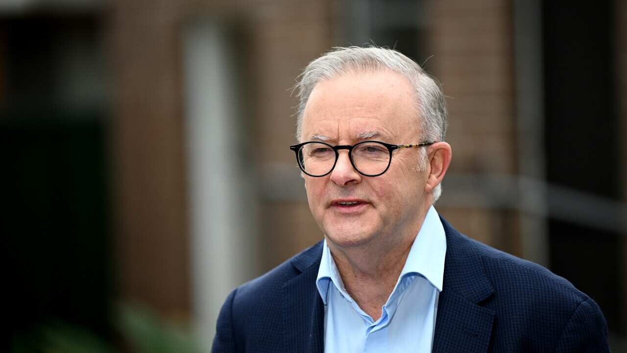 Anthony Albanese wearing a dark blue jacket and blue shirt speaking outside.