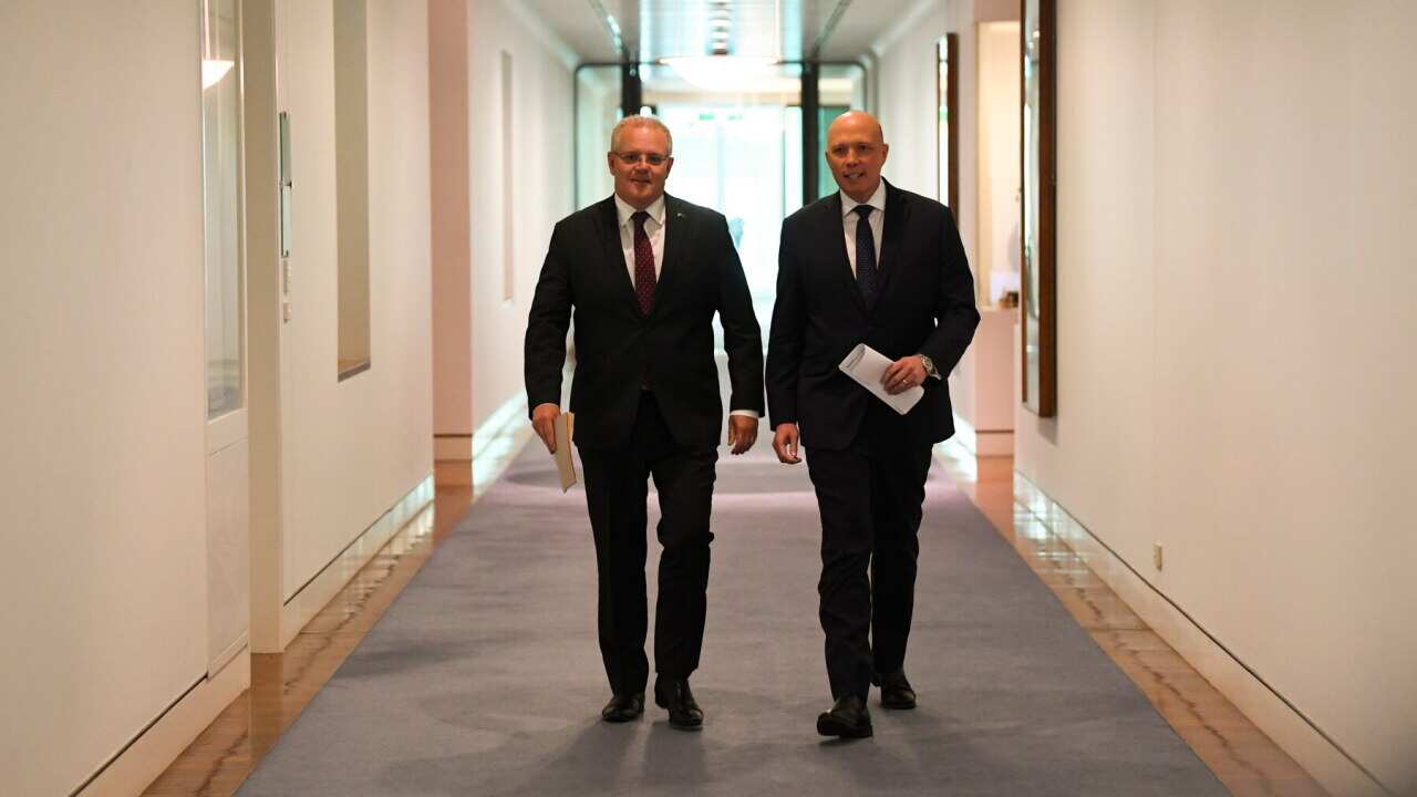 PM Scott Morrison (left) and Home Affairs Minister Peter Dutton on their way to a media conference