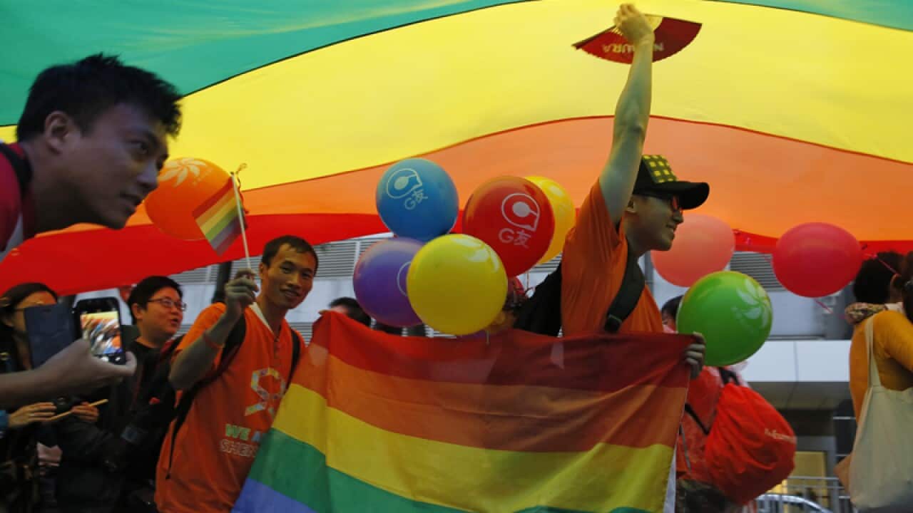 Participants raise a rainbow flag, a symbol of the gay rights movement