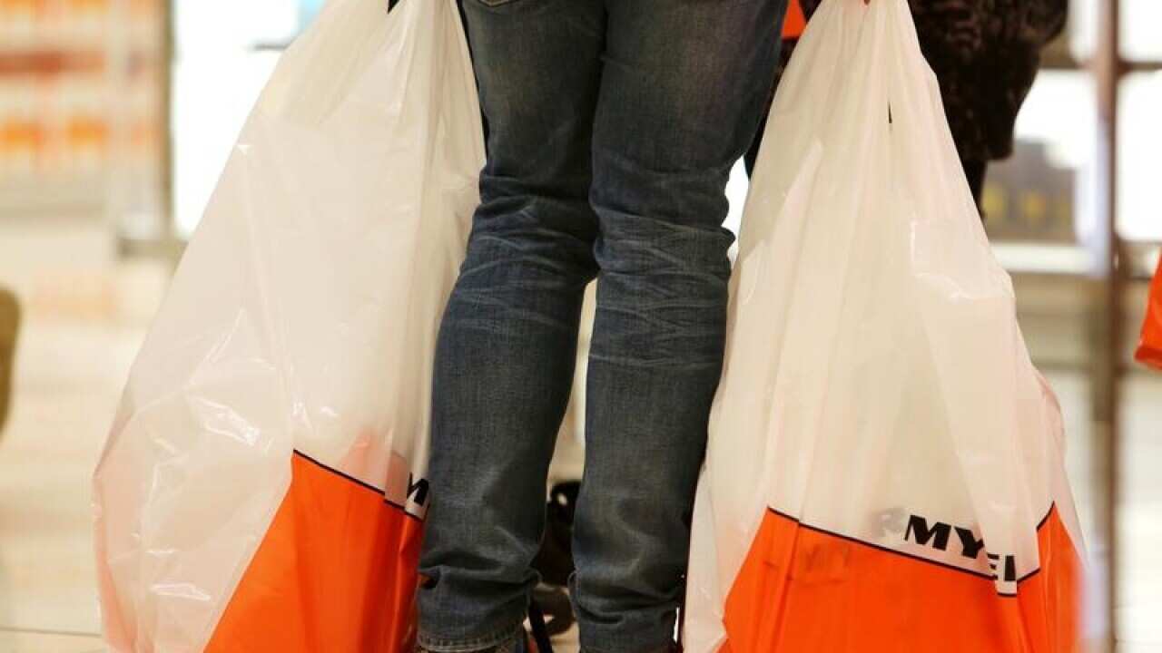 A shopper carries shopping bags