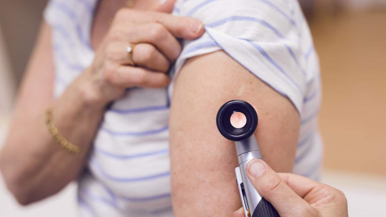 Doctor examining senior womans skin