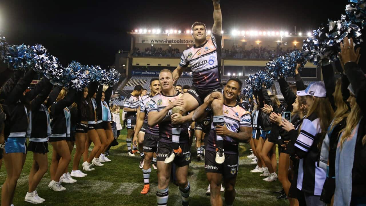 Cronulla Sharks hooker Michael Ennis is lifted from the field