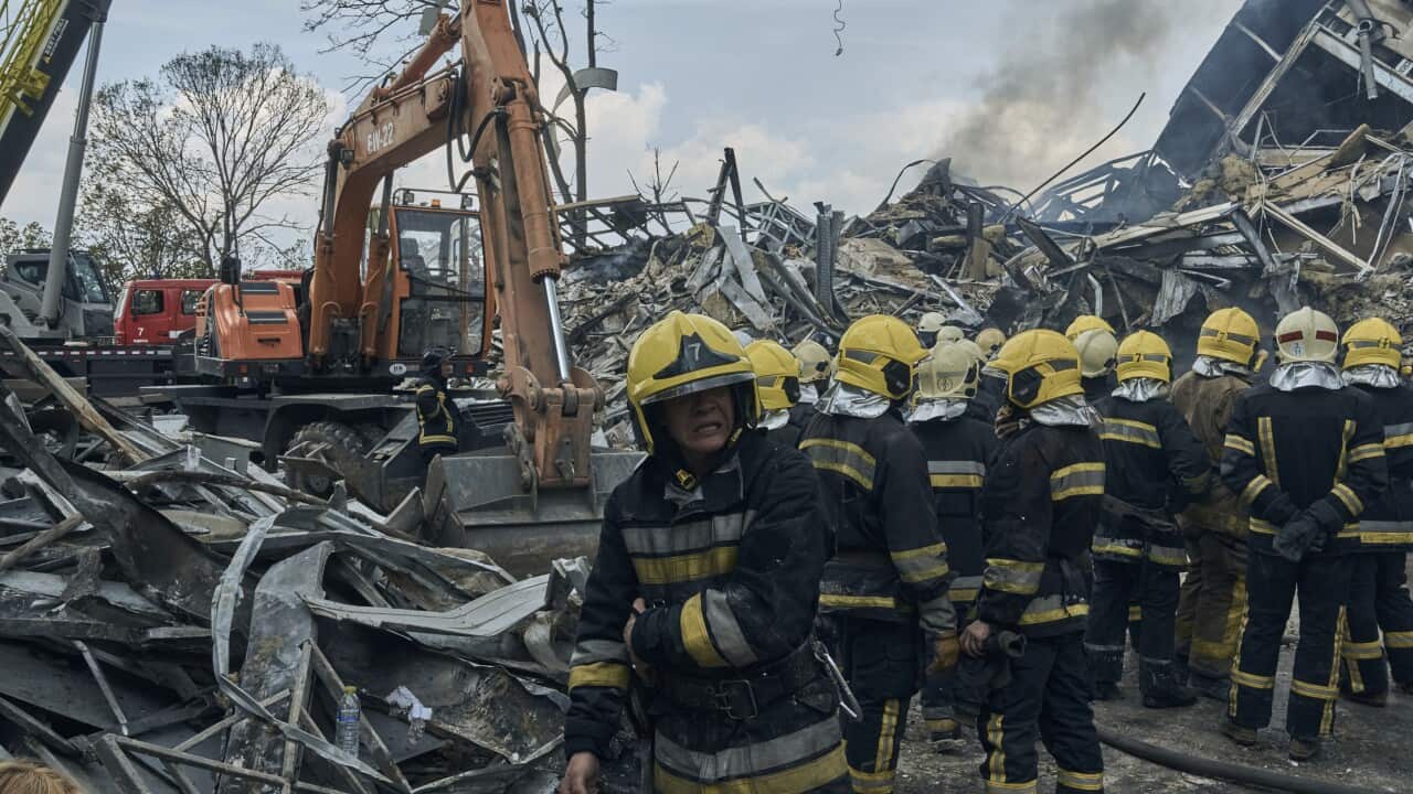 Emergency service personnel working amongst debris and destroyed buildings.