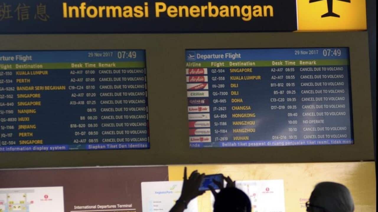 A tourist uses mobile phone to take pictures of flight information.