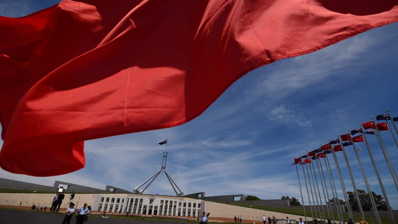 File: Chinese flags fly high outside the Australian Parliament House in Canberra