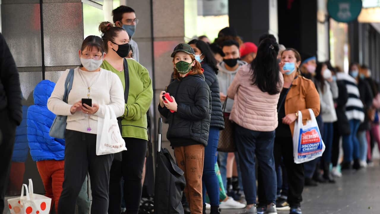 People are seen lining up outside of a retail store in Melbourne, Friday, October 29, 2021