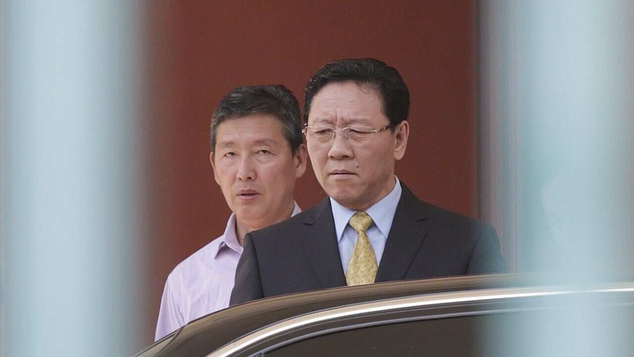 North Korea's ambassador to Malaysia, Kang Chol (R), reacts while leaving the North Korean embassy in Kuala Lumpur, Malaysia