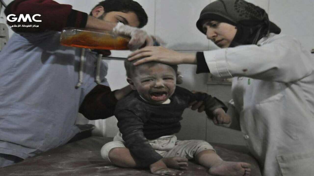 Aid workers treat a child in a makeshift hospital