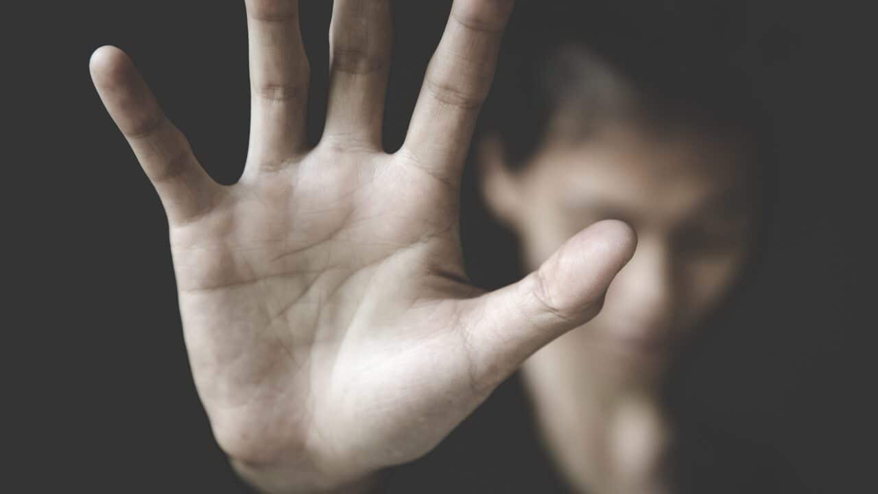 A woman raises her hand against domestic violence in this campaign photo.