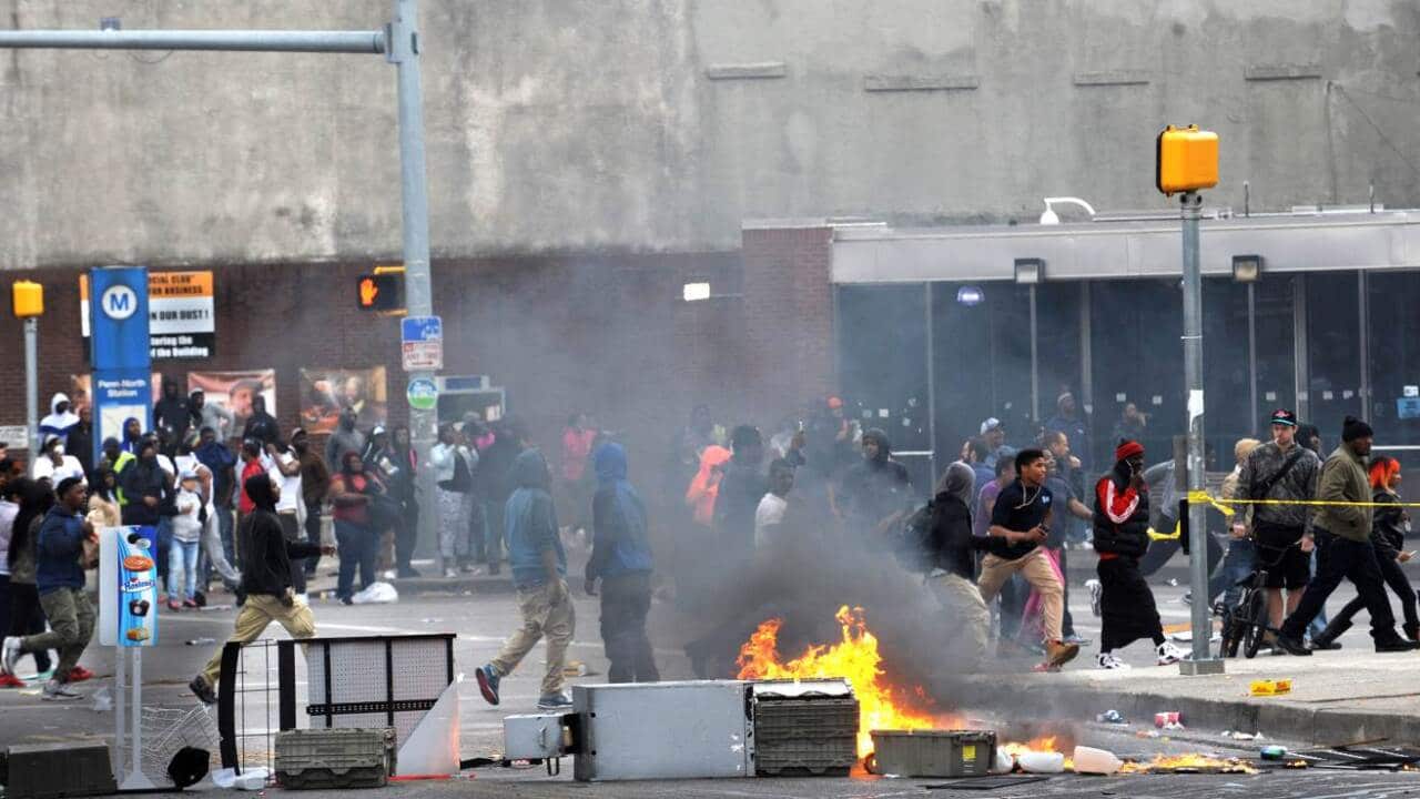 A fire burns in the street Monday, April 27, 2015, during unrest following the funeral of Freddie Gray in Baltimore. (AAP)