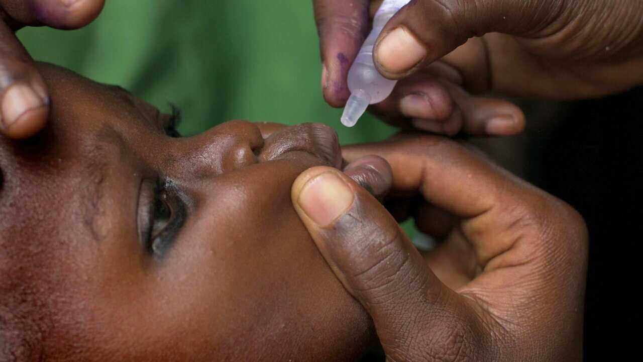 A Nigerian child receives a dose of the polio vaccine.