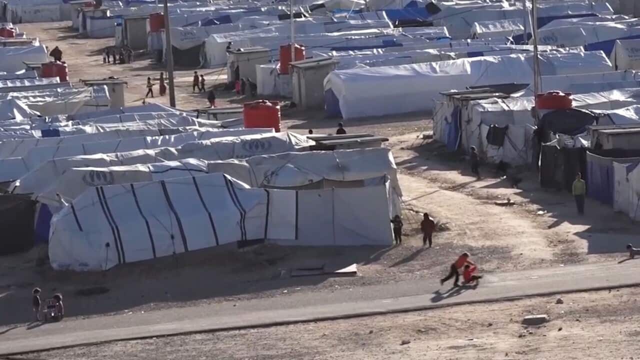Tents that make up the refugee camp, separated by dirt paths where children play.