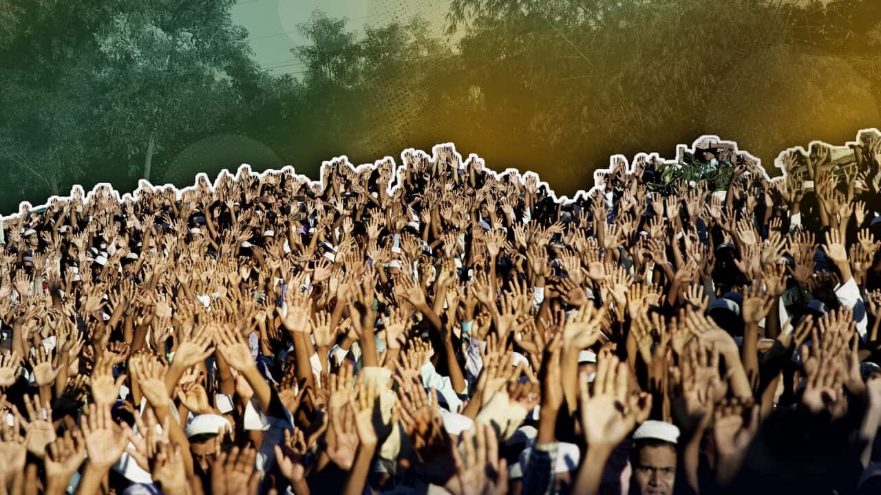 A crowd of people holding their hands up in the air