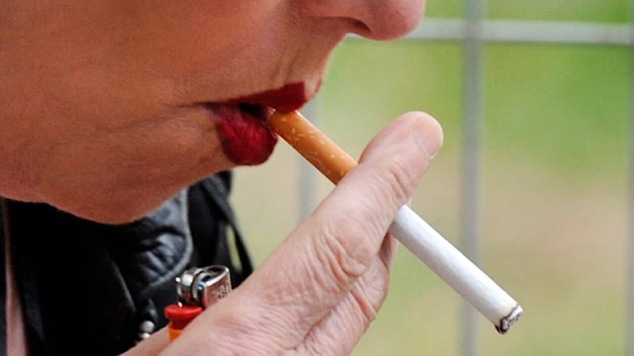 A woman smokes a cigarette.