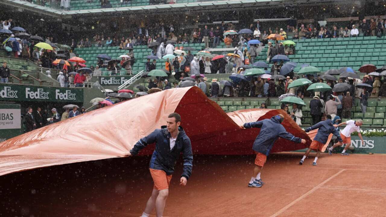 Stadium workers cover the clay court
