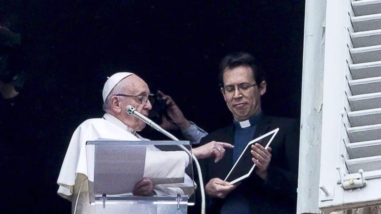 Pope Francis swipes a tablet to launch the app