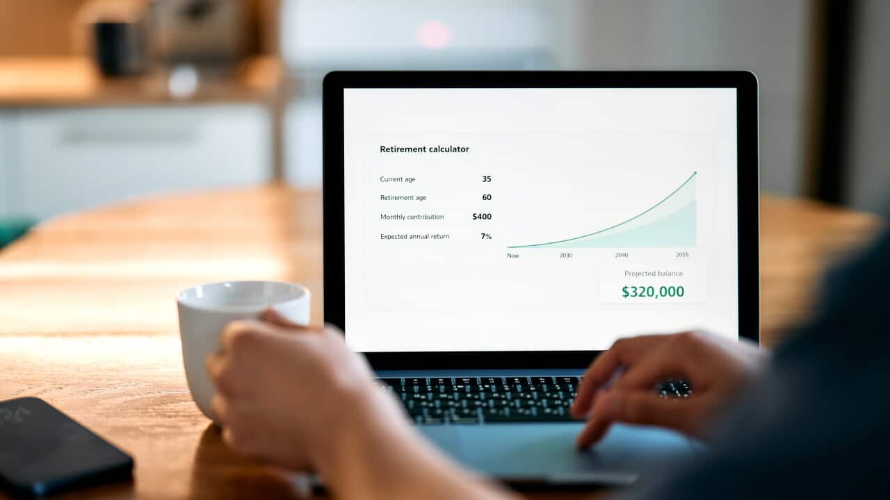 Man reviewing a retirement savings calculator on a laptop at home, suitable for pension planning, retirement income, long term savings, financial forecasting, wealth management and personal finance concepts.