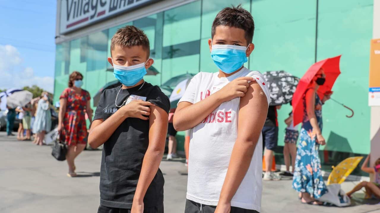 Brothers Louise and Harry Taylor-Bishop pose for a photo after receiving their first vaccine at Kippa Ring Communication Vaccination Clinic