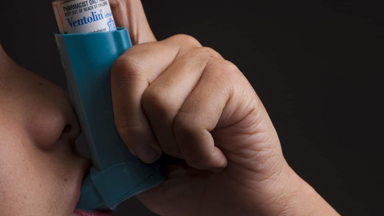 A asthma inhaler is pictured in use