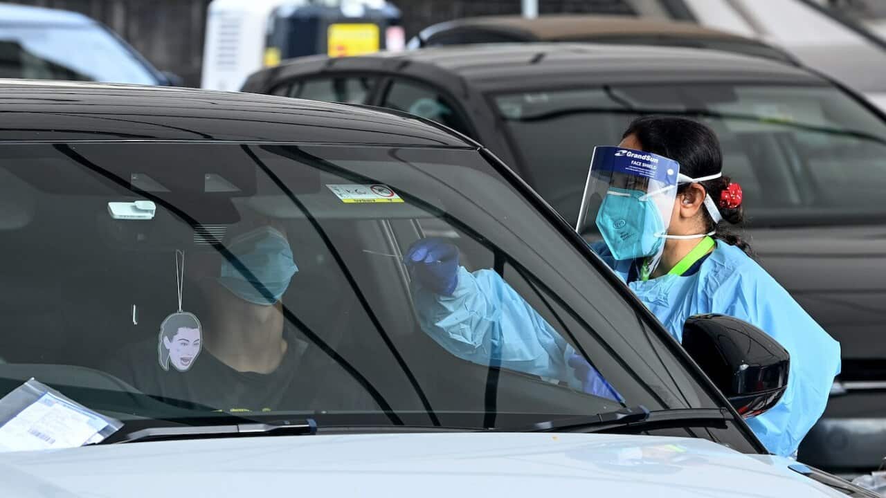 Health care workers administer COVID-19 PCR tests at the St Vincent’s Drive-through Clinic at Bondi Beach in Sydney earlier this year.