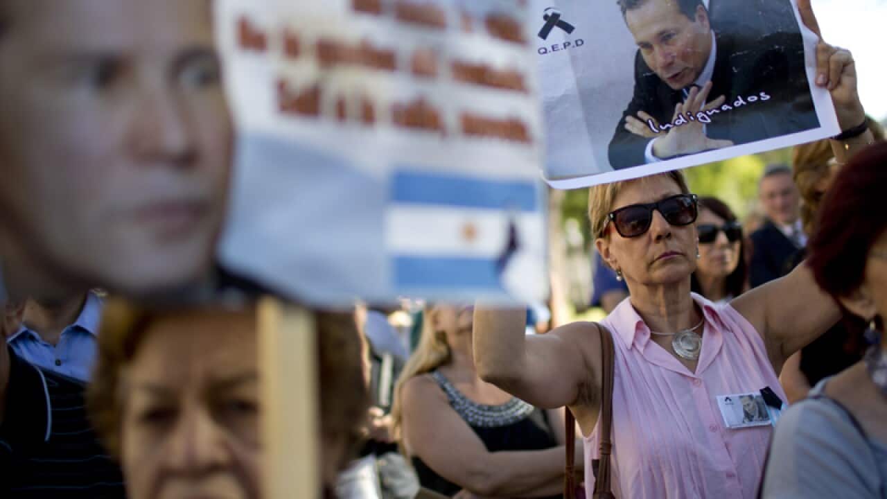 demonstrators hold images of the late prosecutor Alberto Nisman